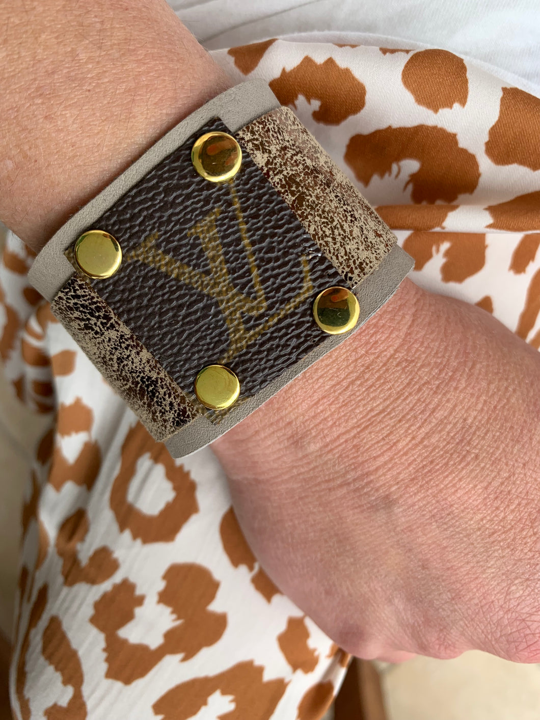 Beautiful leather cuff crafted from cloud gray Deerskin, featuring a metallic leather overlay and vintage LV canvas square accent.